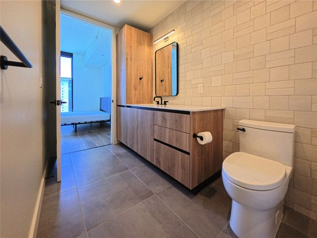 Bathroom with vanity, tile patterned floors, and tile walls | Image 8