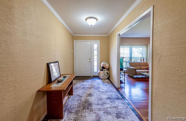 Entryway with crown molding and wood finished floors | Image 17
