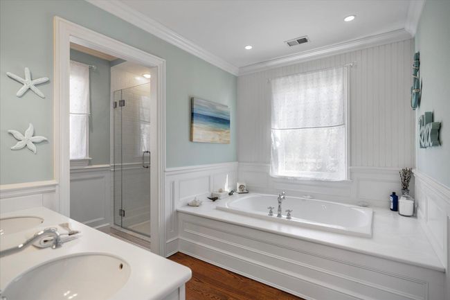 Bathroom featuring a stall shower, crown molding, a sink, a garden tub, and visible vents | Image 21