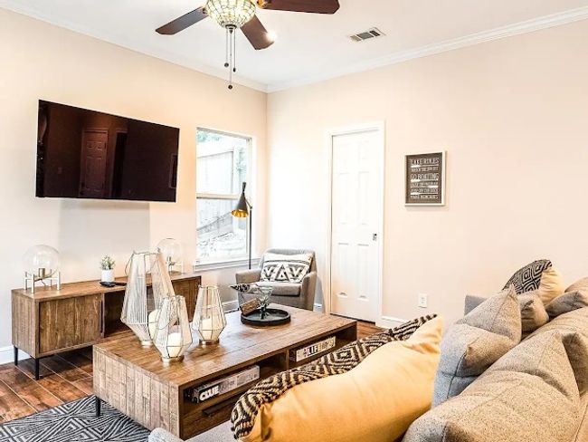 Living area featuring baseboards, dark wood-style flooring, visible vents, ceiling fan, and crown molding | Image 9
