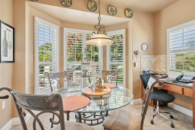 Dining space featuring an office area and light tile patterned floors | Image 9