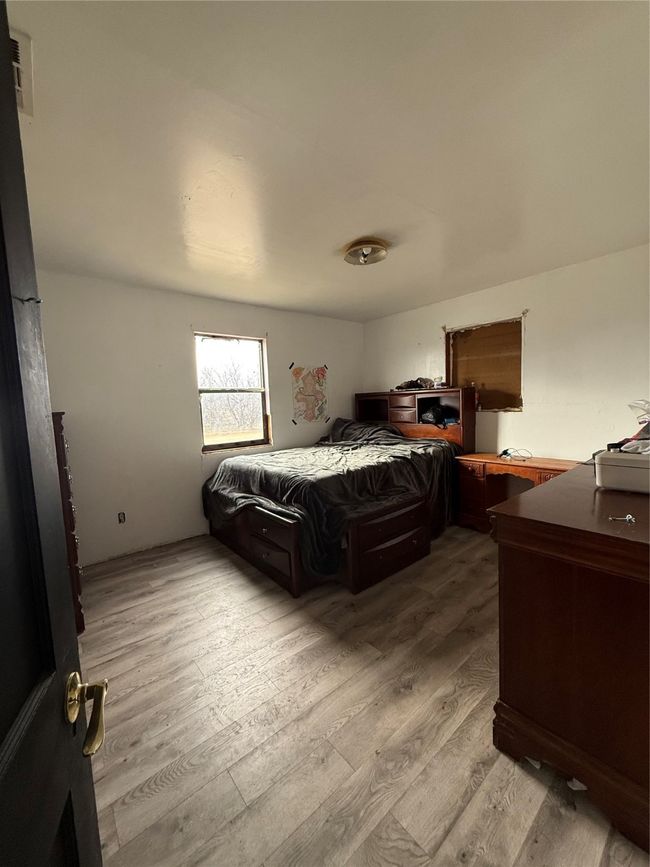 Bedroom with light wood finished floors | Image 15
