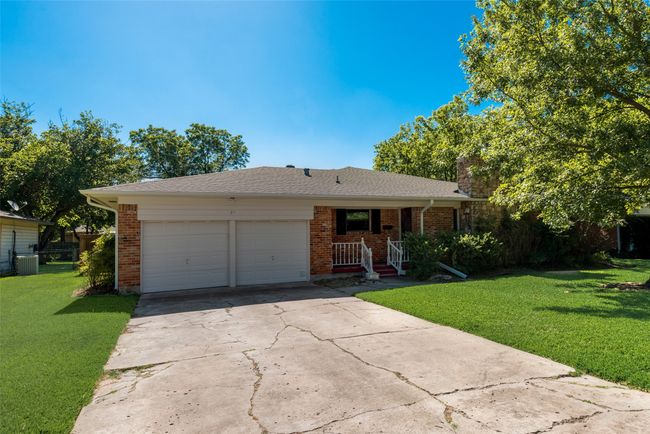 Ranch-style house featuring a front lawn, a chimney, brick siding, and concrete driveway | Image 4