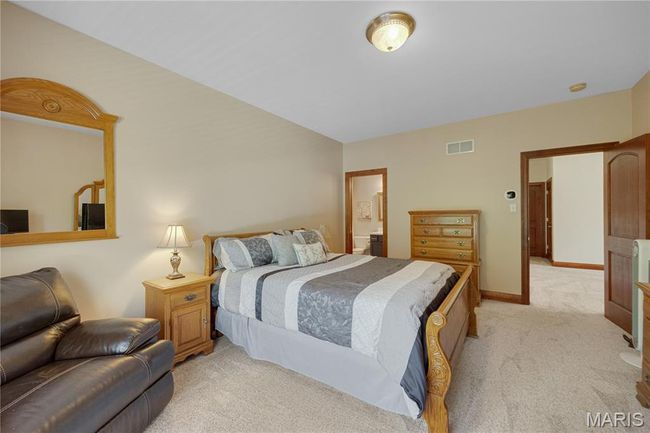 Bedroom featuring light colored carpet and ensuite bath | Image 35