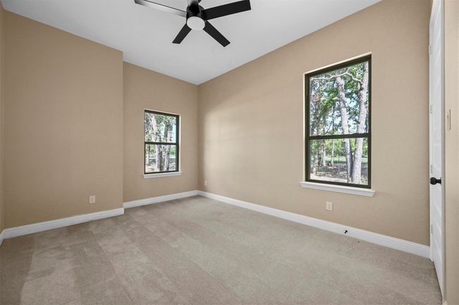 Spare room featuring a ceiling fan, light carpet, and baseboards | Image 19