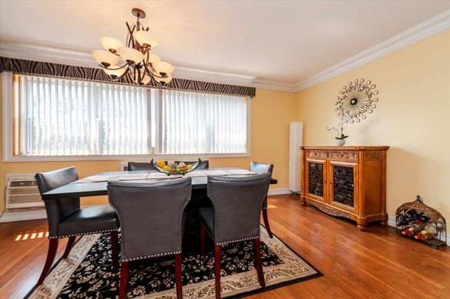 Dining area featuring a chandelier, crown molding, and wood finished floors | Image 8