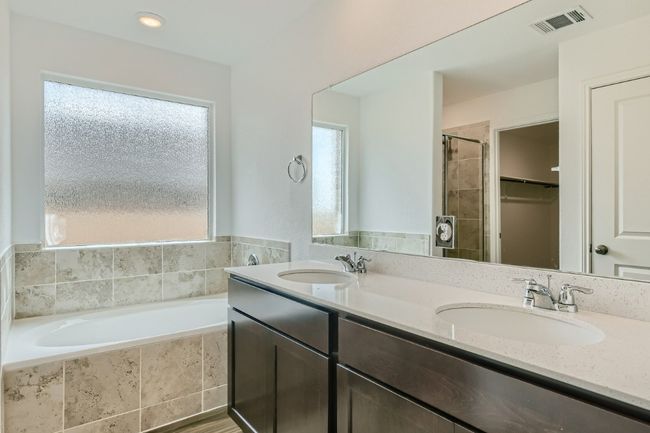 Bathroom with double vanity, a bath, a tile shower, and a spacious closet | Image 12