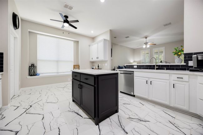 Kitchen with stainless steel dishwasher, ceiling fan, light marble finish floors, white cabinets, and recessed lighting | Image 4