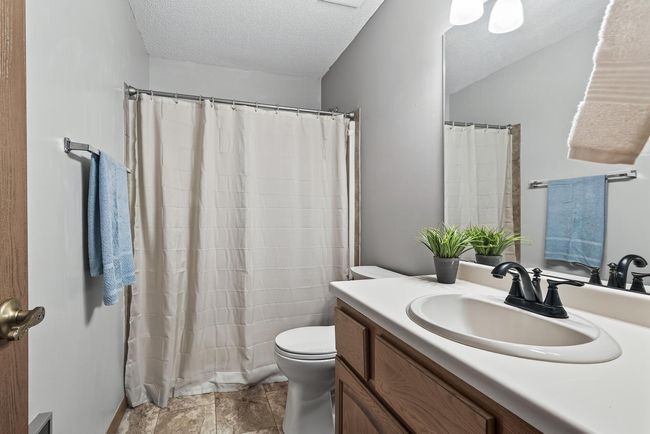 The main bathroom includes a convenient bathtub/shower combo, updated luxury vinyl tile flooring, and ample cabinet storage space in the vanity. | Image 9