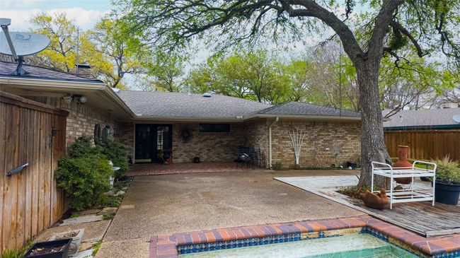 Back of house featuring a shingled roof, a patio area, fence, and brick siding | Image 6