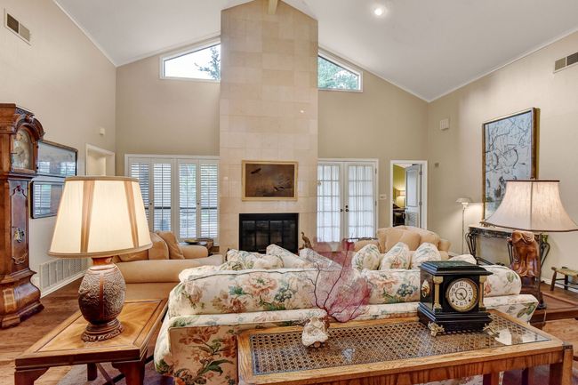 Living room with wood finished floors, high vaulted ceiling, ornamental molding, baseboards, and a tiled fireplace | Image 9