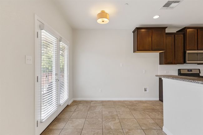 Kitchen with stainless steel appliances, dark brown cabinets, recessed lighting, and light tile patterned floors | Image 16