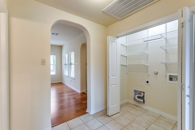 Laundry room featuring hookup for an electric dryer, arched walkways, washer hookup, and light tile patterned floors | Image 16