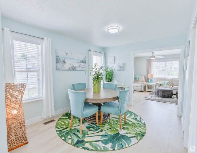 Dining room with wood finished floors, ceiling fan, and baseboards | Image 26
