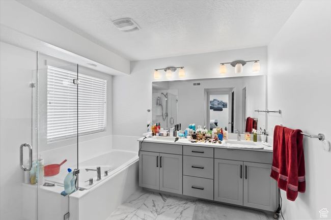 Bathroom featuring a sink, double vanity, marble finish floor, a shower stall, and a garden tub | Image 13