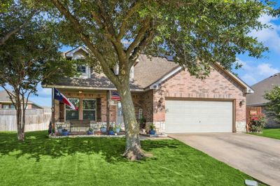 View of front of property featuring a front lawn, a garage, and a porch | Image 1