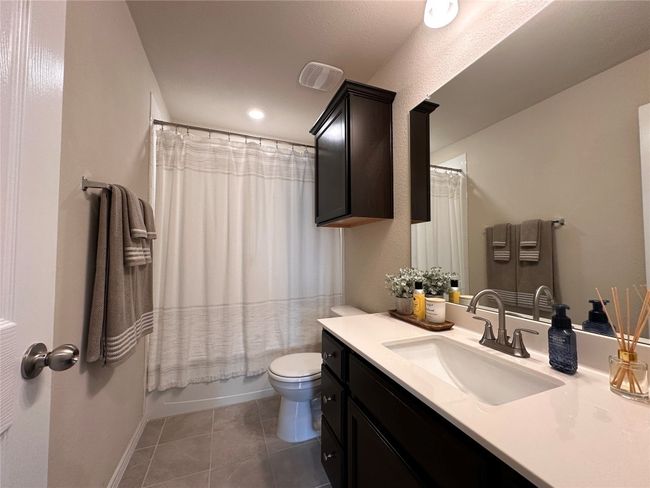 Full bathroom featuring vanity, toilet, tile patterned floors, baseboards, and shower / bath combination with curtain | Image 11