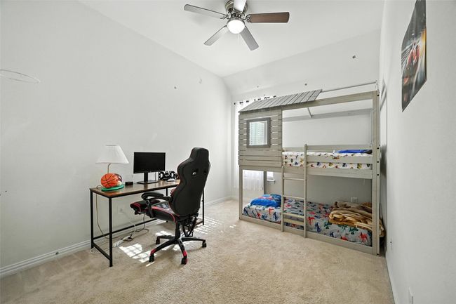 Carpeted office with lofted ceiling and ceiling fan | Image 24