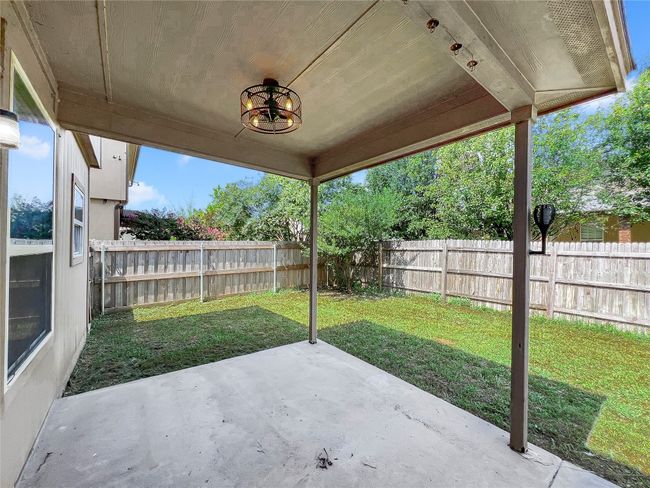 Fenced backyard with a patio area | Image 26