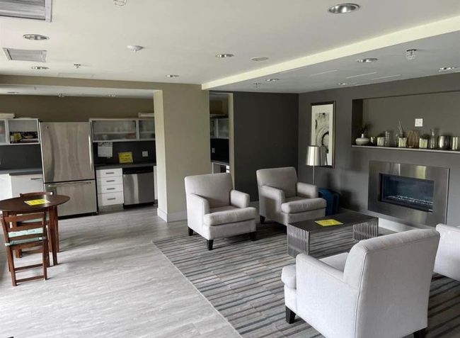 Living room featuring recessed lighting, a glass covered fireplace, visible vents, light wood-style flooring, and baseboards | Image 19
