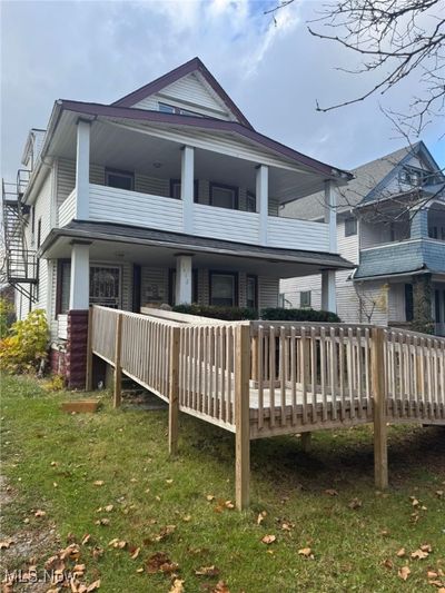 Rear view of house with a lawn and a deck | Image 1