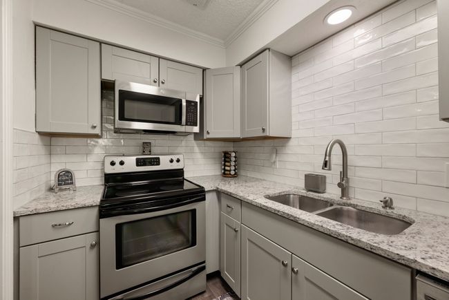 Kitchen with crown molding, gray cabinetry, stainless steel appliances, and a sink | Image 8