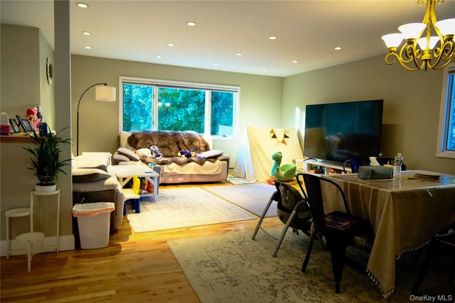 Living room featuring light wood-style floors, a chandelier, and recessed lighting | Image 12