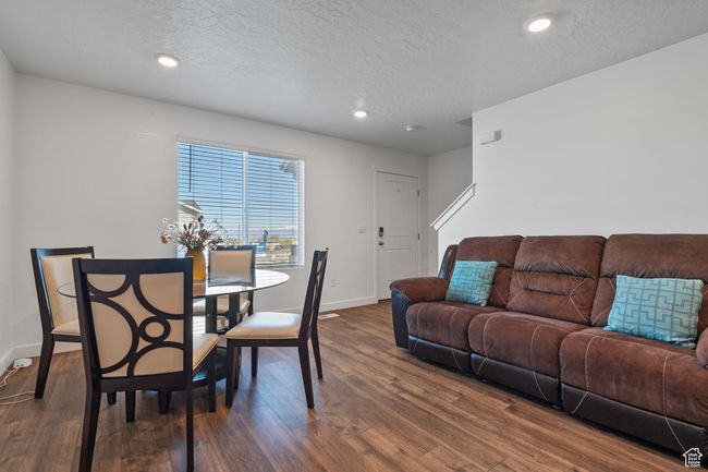 Dining area featuring baseboards, a textured ceiling, dark wood-style floors, and recessed lighting | Image 4