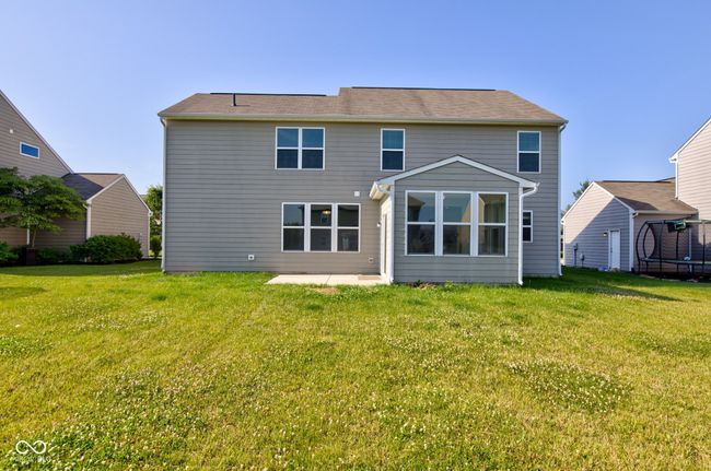 rear view of house with a trampoline, a patio area, and a yard | Image 49