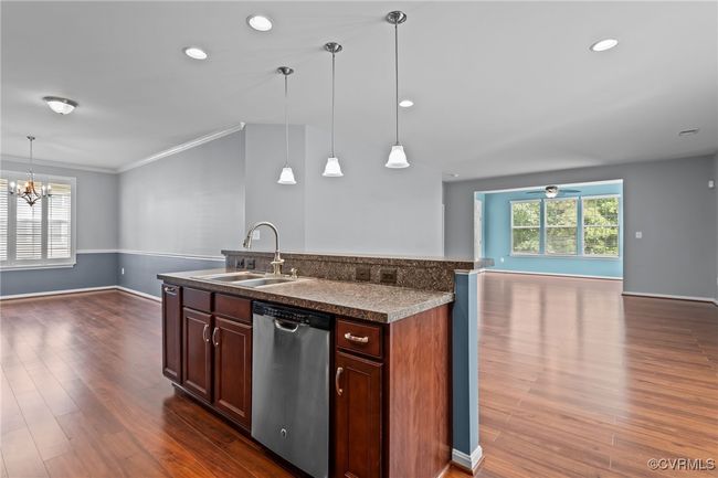 Kitchen with dishwasher, open floor plan, dark wood-type flooring, a chandelier, and ornamental molding | Image 5