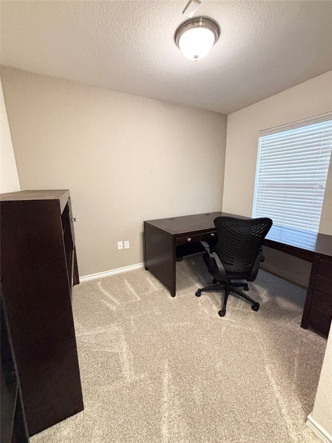 Carpeted office space with a textured ceiling and baseboards | Image 5