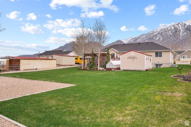 View of yard featuring an outdoor structure, a residential view, a mountain view, and a shed | Image 34
