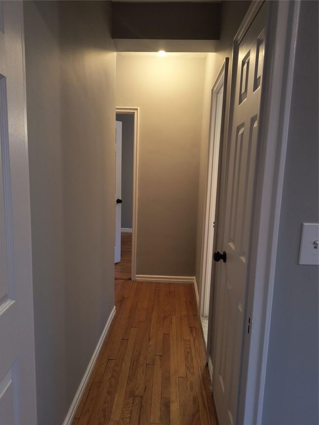 Hallway featuring baseboards and wood finished floors | Image 37