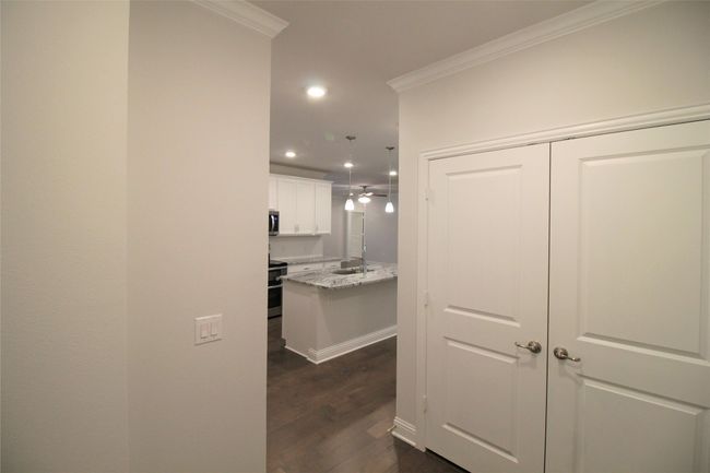 Corridor featuring dark wood finished floors, crown molding, recessed lighting, and baseboards | Image 6