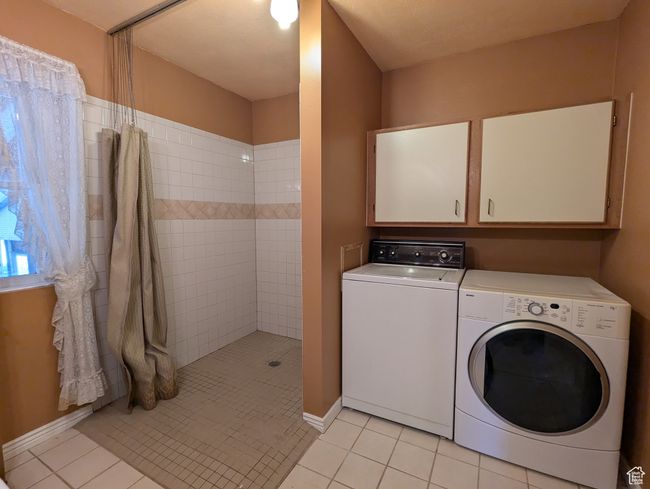 Laundry room featuring light tile patterned floors, laundry area, and independent washer and dryer | Image 13