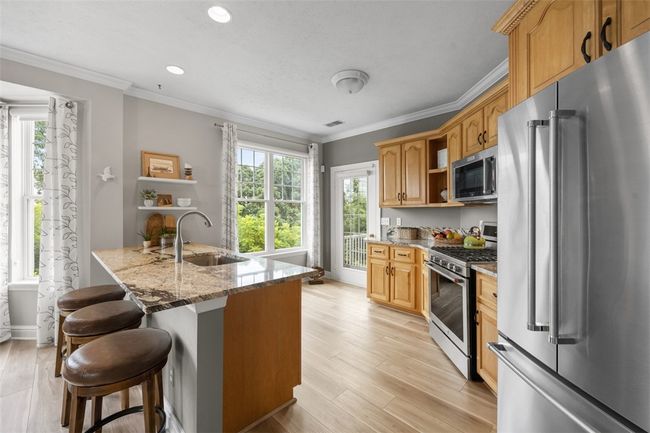 Start you day with a hot cup of coffee at the large breakfast island. Enjoy the stainless steel Kitchenaid appliances. | Image 14