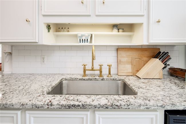 Kitchen view of a sink, open shelves, and decorative backsplash | Image 12
