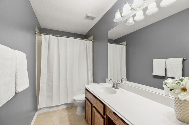 The upstairs bathroom offers a long vanity, updated lighting, and a neutral palette that fits any style. | Image 31