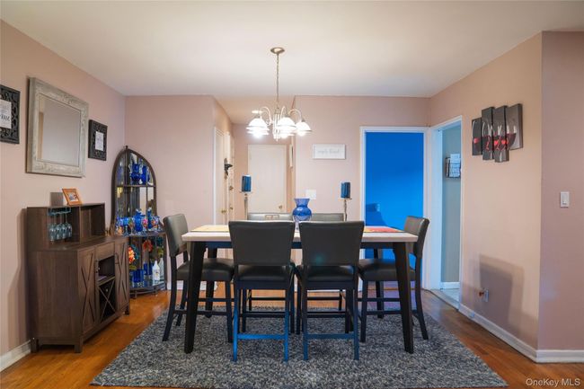 Dining space featuring a chandelier and wood finished floors | Image 4