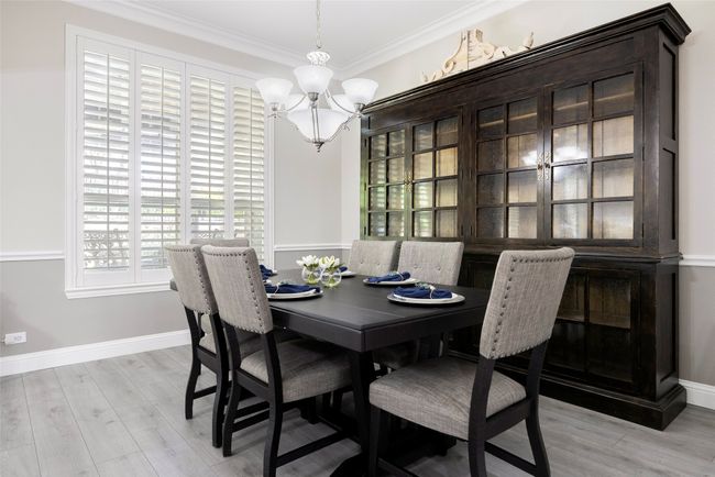 Dining space with a chandelier and open concept to other living areas, perfect for hosting. | Image 10