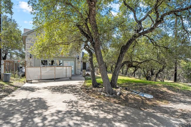 View of front facade featuring stone siding, concrete driveway, and fence | Image 32