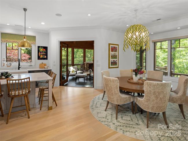 Flow between kitchen and dining area and out to screened porch. | Image 11
