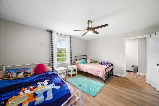 Bedroom with wood finished floors and a ceiling fan | Image 15