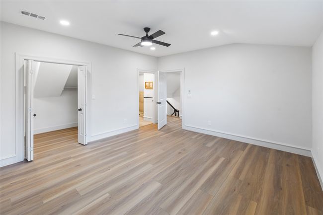 Unfurnished bedroom with light wood finished floors, recessed lighting, ceiling fan, a spacious closet, and a closet | Image 37