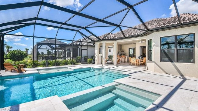 View of swimming pool with a pool with connected hot tub, a lanai, a patio, outdoor dining space, and ceiling fan | Image 17