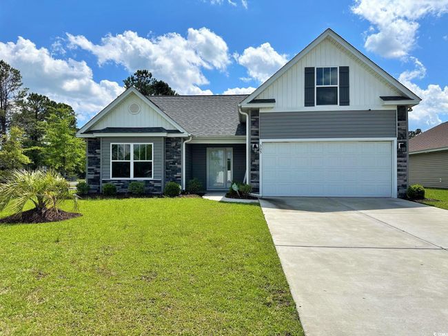 View of front of house featuring board and batten siding, driveway, a garage, and a front lawn | Image 20