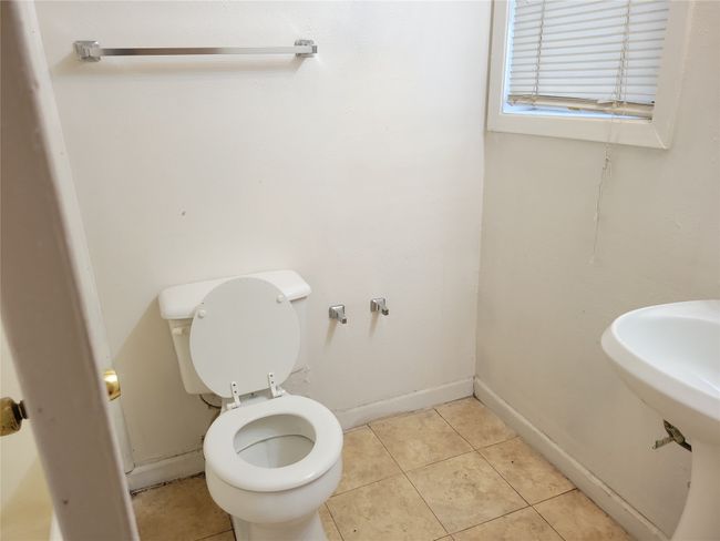 Bathroom with tile patterned floors, toilet, and baseboards | Image 10