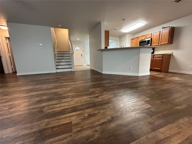 Unfurnished living room with dark wood-style flooring and stairs | Image 21