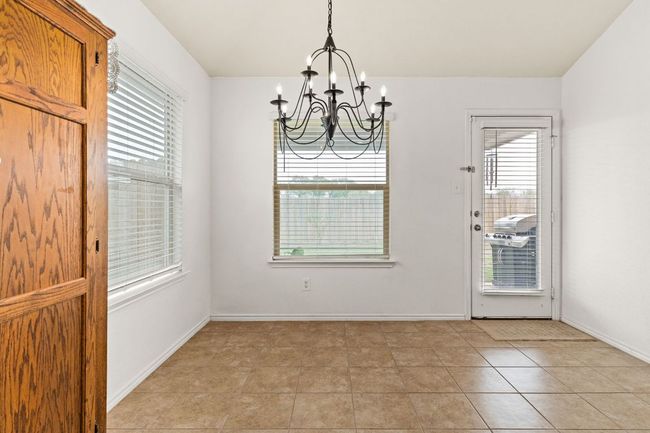 Unfurnished dining area featuring a chandelier, baseboards, and a wealth of natural light | Image 11