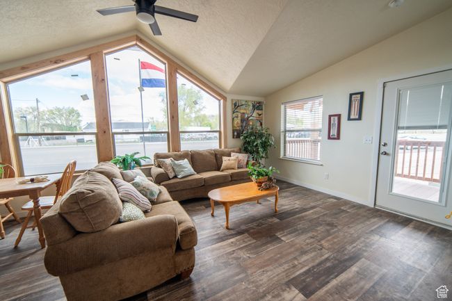 Living room featuring dark wood-type flooring, lofted ceiling, and a textured ceiling | Image 4